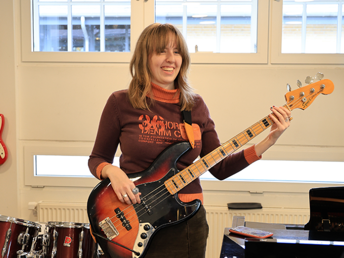Ung der spiller elbas i lokale med instrumenter
